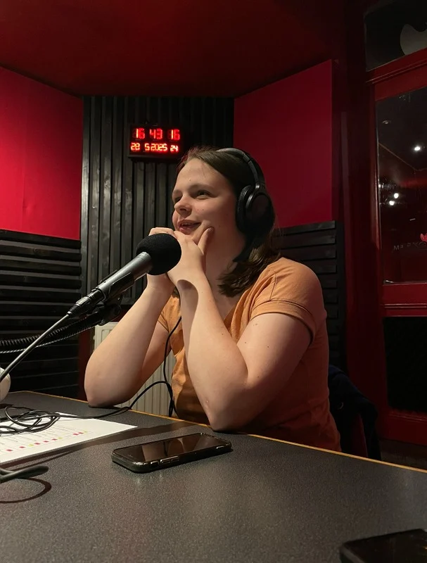 Clara avec un casque devant un microphone de radio